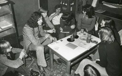 ARH Slg. Bartling 2612, Teestube an der Schulstraße an der Liebfrauenkirche, acht junge Leute bei Zigarette und Tee am Tisch sitzend und diskutierend, Neustadt a. Rbge., 1973