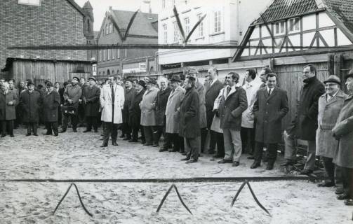 ARH Slg. Bartling 2693, Neubau der Kreissparkasse an der Marktstraße, Richtfest, die Gäste vor dem Bauzaun entlang der Marktstraße nebeneinander stehend und auf den Eingangsbereich schauend, Neustadt a. Rbge., 1971
