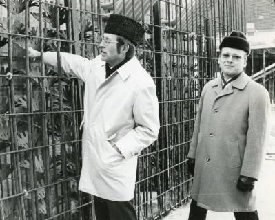ARH Slg. Bartling 2735, Werbeleiter Rolf Hantelmann und ? Krüger in Wintermantel und mit Pelzmütze (Kosakenhut) vor einem Eisengitter, Neustadt a. Rbge., 1971