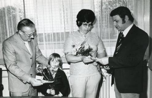 ARH Slg. Bartling 2776, Gratulation einer Gewinnerin und eines Kindes im Prämiensparen durch den Leiter der Sparkassenzweigstelle Havelse Günter Gidius (l.) und N. N., Gruppenfoto, Havelse, 1974