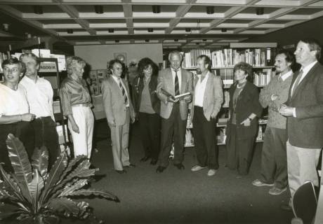 ARH Slg. Bartling 2885, Kooperative Gesamtschule (KGS), Lehrpersonal beim Stehkonvent in der Bibliothek mit Schulleiter Herbert Stoepper (2. v. r.), Neustadt a. Rbge., um 1974