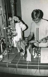 ARH Slg. Bartling 2926, Gymnasium an der Gaußstraße, Chemielehrsaal, zwei Personen bei der Durchführung von chemikalischen Versuchen am Tisch, Neustadt a. Rbge., 1971