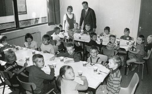 ARH Slg. Bartling 2995, Sonderschule, Kaffeetafel der jüngeren Schüler*innen, dahinter stehend Lehrerin N. N. und Rektor Ewalt Behrens, Neustadt a. Rbge., 1971