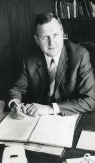 ARH Slg. Bartling 3006, Sonderschule, Rektor Ewalt Behrens, am Schreibtisch sitzend, Einzelporträt, Frontansicht, Neustadt a. Rbge., 1971