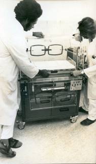 ARH Slg. Bartling 3164, Kreiskrankenhaus (später: KRH Klinikum Neustadt a. Rbge.), Lindenstraße 75: Begutachtung eines Inkubators für Frühgeborene durch zwei Ärzte, links Dr. Benjamin Baffoe-Bonnie aus Kumasi (Ghana), Neustadt a. Rbge., 1973