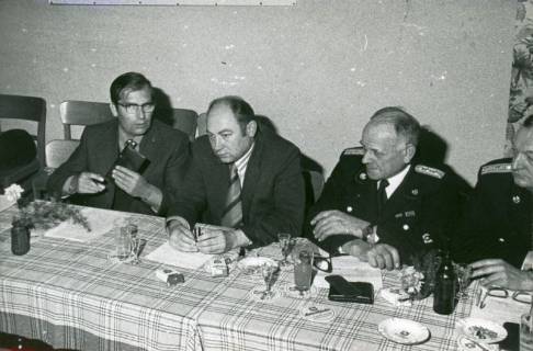 ARH Slg. Bartling 3329, Kreisdirektor Wolfgang Kunze (v. l.), Amtsrat Heinz Busse (Ordnungsamt) sowie uniformierte Feuerwehrleute N. N. und Henry Hahn am Vorstandstisch sitzend, Neustadt a. Rbge., 1974