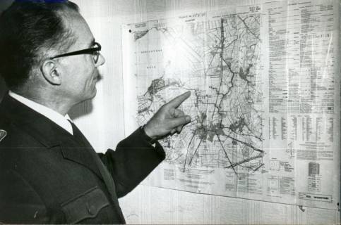 ARH Slg. Bartling 3344, Polizei-Hauptkommissar Bode, Blick über die Schulter auf das an der Wand hängende Messtischblatt von Wunstorf, 1971