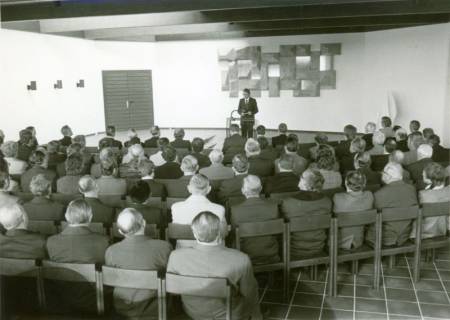 ARH Slg. Bartling 3500, Einweihung des Friedhof Lüningsburg, Bürgermeister Fritz Temps am Rednerpult vor den teilnehmenden Gästen in der Aussegnungshalle, Neustadt a. Rbge., 1976