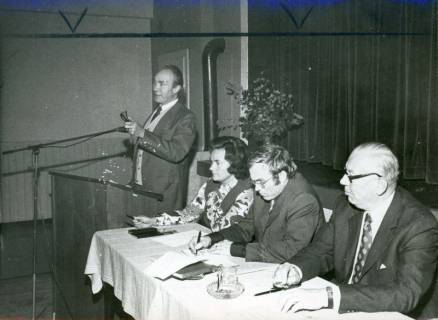 ARH Slg. Bartling 3546, Kirchenkreistag, der Superintendent N. N. stehend am Rednerpult, daneben am Vorstandstisch drei Personen sitzend, Neustadt a. Rbge., 1973