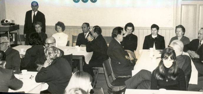 ARH Slg. Bartling 3547, Dia-Vortrag des Pastors Wolf-Hermann Sprick (l.) im Gemeindehaus der Liebfrauen-Kirchengemeinde, Blick auf die Teilnehmenden, die an Tischen sitzend, Neustadt a. Rbge., 1970