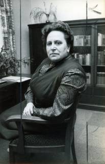ARH Slg. Bartling 3586, Vorsitzende des Landfrauenvereins Reinecke, im Sessel am Schreibtisch sitzend, im Hintergrund ein Bücherschrank, Einzelporträt, Frontalansicht, Neustadt a. Rbge., 1972