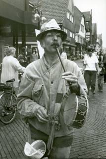 ARH Slg. Bartling 3678, Werbeauftritt des 1. Vorsitzenden des Mühlenvereins Dudensen Dr. Klaus Hespe mit Hut, Geldtopf, Flöte und Trommel in der Marktstraße (?), Neustadt a. Rbge., um 1985