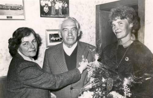 ARH Slg. Bartling 4017, Überreichung eines Blumenstraußes und einer Ehrennadel für 50jährige Mitgliedschaft im DRK, Ortsgruppe Esperke, an Bernhard Bodenhausen durch zwei Frauen, Esperke, 1987