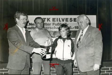 ARH Slg. Bartling 4078, Ziehung der Lose bei einer Verlosung des STK Eilvese (aus Anlass der Neustädter Fußball-Stadtmeisterschaft) durch einen Schüler und drei Erwachsene (rechts: Bürgermeister Henry Hahn), Eilvese, um 1988