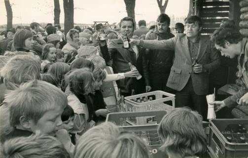 ARH Slg. Bartling 4107, Verteilung von Getränken bei der Eröffnung des Kinderspielplatzes, Blick auf die Getränkekästen, die verteilenden Erwachsenen und die drängelnden Kinder, Eilvese, um 1974