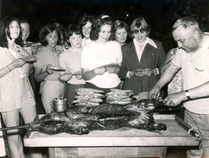ARH Slg. Bartling 4232, Helstorfer Heide, Zerlegung eines gegrillten Spanferkels und Verteilung der Portionen an wartende Frauen, Helstorf, 1970