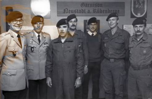 ARH Slg. Bartling 4332, Gruppe von sieben Soldaten in unterschiedlichen Uniformen unter dem Wandschild "Garnison Neustadt a. Rübenberge", Luttmersen, zwischen 1986/1988