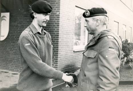ARH Slg. Bartling 4336, Handschlag für einen jungen Obergefreiten durch OTL Streibel vor einem Kasernengebäude mit Wappenschild, Luttmersen, um 1985