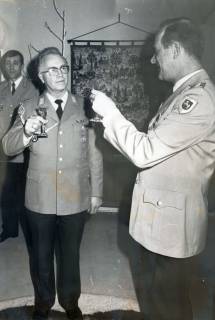 ARH Slg. Bartling 4338, Stabsfeldwebel Rose und  N. N. in Ausgehuniform beim einander Zutrinken mit Sekt, im Hintergrund an der Wand ein Gobelin-Teppich mit historischen Motiven, Luttmersen, um 1985