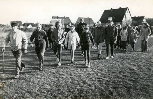 ARH Slg. Bartling 4447, Gemeinsame Wanderung zahlreicher Marienseer als Antwort auf das Fahrverbot, Blick über den Fußballplatz auf die Wohnhäuser der Bebauungsgrenze, Mariensee, 1973