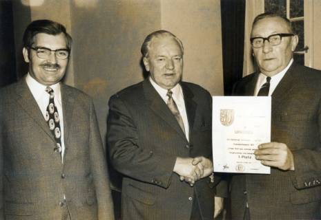 ARH Slg. Bartling 4449, Überreichung einer Urkunde über den 1. Preis beim Wettbewerb "Unser Dorf soll schöner werden" an den Marienseeer Bürgermeister Albert Kohansky (r.) durch den Neustädter Landrat Friedrich Meyer und den Kreisdirektor Wolfgang Kunze (l.), Mariensee, 1971