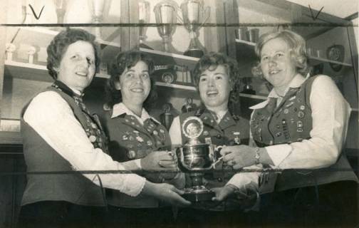 ARH Slg. Bartling 4480, Präsentation eines Pokals, den sie, vor einer Vitrine mit Pokalen stehend, gemeinsam halten, durch vier Schützinnen, Mariensee, 1974