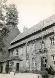 ARH Slg. Bartling 4497, Haupteingang zum Stiftsgebäude und westlicher Giebel der Kirche des Klosters, Baugerüst vor dem Eingang und am Dachreiter der Kirche, Blick von Nordwesten, Mariensee, um 1980