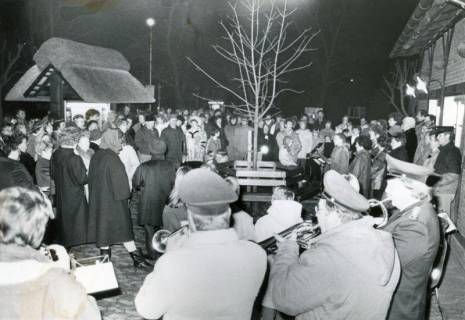ARH Slg. Bartling 4525, Abendlicher Stehkonvent auf dem Aloys-Bunge-Platz mit musikalischer Begleitung, Blick über die Hinterköpfe der Feuerwehrkapelle (2 Ex.), Mardorf, nach 1985