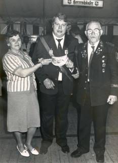 ARH Slg. Bartling 4558, Schützenkönig zwischen den Stiftern der neuen Königskette, dem Ehepaar August und Gertrud Schulz im Festzelt beim Schützenfest, Mardorf, um 1980