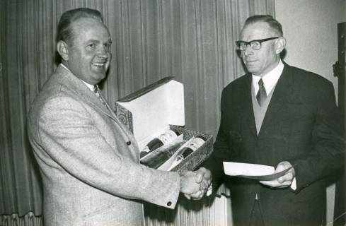 ARH Slg. Bartling 4769, Überreichung eines Weinpräsents anlässlich der Verabschiedung des Rechnungsführers der Gemeinde Willi Gähle (r.) durch Bürgermeister Friedrich Poppe, Otternhagen, 1971