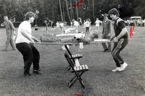 ARH Slg. Bartling 4802, "Spiel ohne Grenzen" Wettspiele der Vereine auf dem Sportplatz: zwei Jugendliche beim Hindernislauf mit Krankentrage, Otternhagen, 1974