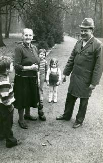 ARH Slg. Bartling 4834, Lina Gähle mit einem Reisigbesen in der Hand bei Reinigungsarbeiten auf dem Weg zur Waldbühne, neben ihr drei Kinder sowie der Vorsitzende des Bühnenvereins Friedrich Poppe, Otternhagen, 1975