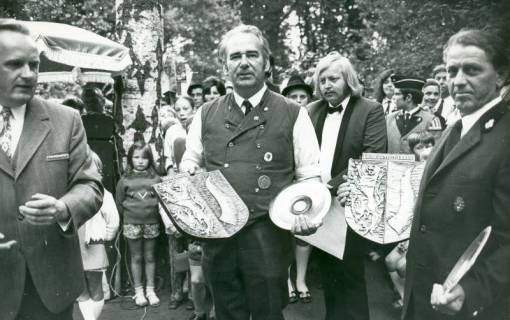 ARH Slg. Bartling 4852, Überreichung von Wappen des Landkreises Neustadt und Silberteller an einen Gast aus Seesen / Harz und einen Gast aus Paternion / Kärnten durch den 1. Vors. des Musikvereins Berggarten Friedel Poppe (l.) beim Heideblütenfest, Otternhagen, um 1972