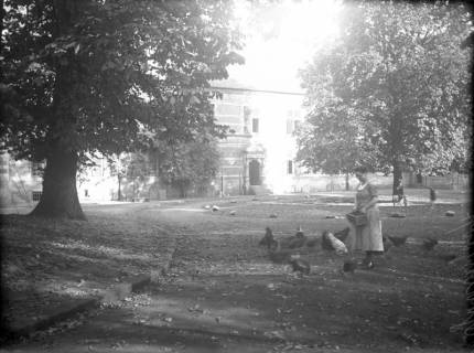 ARH Slg. Grabenhorst 16, Unbekannte Dame bei der Fütterung von Hühnern im Innenhof des Schlosses Landestrost, Blick auf den Ostflügel, Neustadt a. Rbge., vor 1924