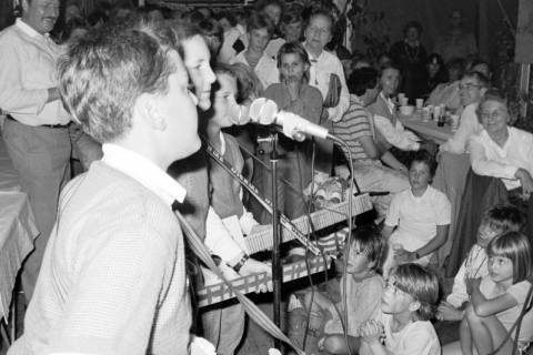 ARH Slg. Weber 02-004/0006, Drei Jungen singen vor Kindern und Erwachsenen auf einer Karnevalsveranstaltung?, zwischen 1980/1990