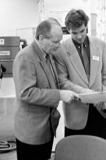ARH Slg. Weber 02-010/0004, Zwei Männer schauen in einer Ausstellung? gemeinsam auf Unterlagen, zwischen 1980/1990
