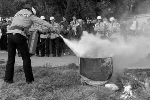 ARH Slg. Weber 02-020/0001, Ein Mitglied der Feuerwehr löscht vor weiteren Mitgliedern einen Brand bei einer Übung, zwischen 1980/1990