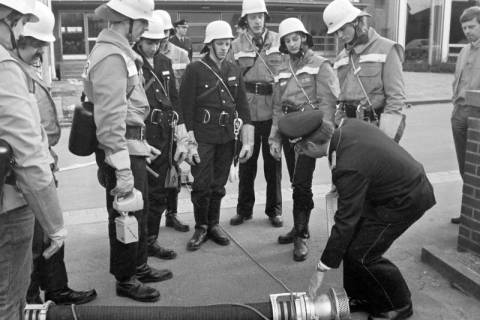 ARH Slg. Weber 02-020/0015, Abnahmeprüfung zum Feuerwehrgrundlehrgang für Gehrdener Ortsfeuerwehren mit Kreisausbildungsleiter Klaus-Dieter Koch (gebückt) aus Laatzen und Helmuth Temps (rechts) auf dem Schulhof der Grundschule Am Castrum, Gehrden, nach 1982