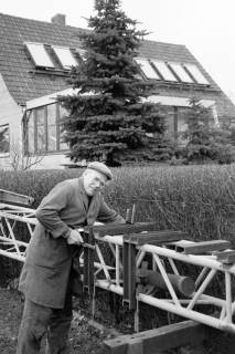 ARH Slg. Weber 02-022/0004, August Katz bei Handwerksarbeiten in seinem Garten, im Hintergrund seine selbst hergestellte Sonnenkollektoranlage, Northen, zwischen 1980/1990