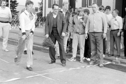 ARH Slg. Weber 02-032/0004, Ein Mann beim Rutenweitwurf vor der Alten Schule/Dorfgemeinschaftshaus während des Straßenfest in Lenthe, zwischen 1980/1990