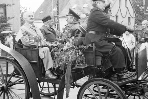 ARH Slg. Weber 02-057/0003, Gehrdens Bürgermeister Helmut Oberheide mit Mitgliedern der Feuerwehr auf einer Pferdekutsche bei einem Festumzug in der Lange Feldstraße / Ecke Gärtnereiweg, Alt-Gehrden, zwischen 1980/1990
