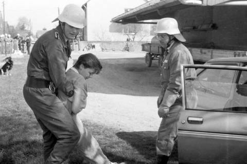 ARH Slg. Weber 02-066/0006, (v. l.) Christian Meier und Detlef Meyhöfer beim Leistungsmarsch der Feuerwehr Northen auf einem Bauernhof bei der Übung, eine bewusstlose Person aus einem Auto zu retten, zwischen 1980/1990