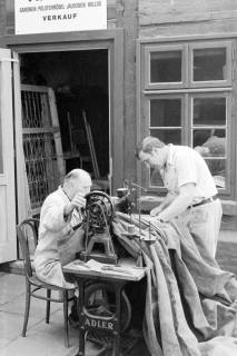ARH Slg. Weber 02-085/0014, Inhaber Fritz Liecker an einer Nähmaschine vor seiner Werkstatt in der Neuen Straße, Gehrden, zwischen 1970/1980
