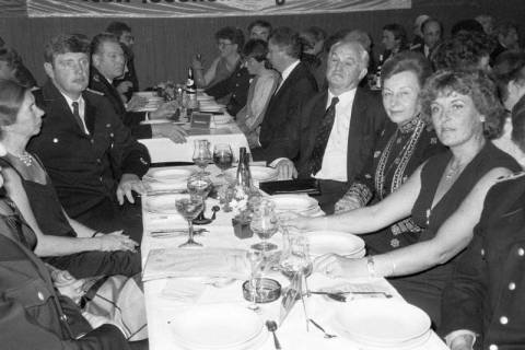 ARH Slg. Weber 02-089/0001, V.l. Siegrid Narten, Stadtbrandmeister Fritz Narten, Ortsbrandmeister Günter Baumgarten, Helmut Ammertmann, Bürgermeister Helmut Oberheide, Luise Oberheide und Ursula Gröper an einem festlich gedeckten Tisch, Gehrden, zwischen 1980/1990