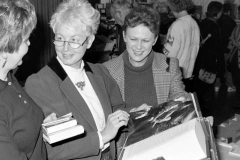 ARH Slg. Weber 02-093/0006, Sabine Berkefeld vom Pfarrgemeinderat der St. Bonifatius-Kirche (Mitte) und weitere Personen auf einem Bücherbasar?, zwischen 1980/1990