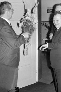 ARH Slg. Weber 02-099/0023, Gehrdens Stadtdirektor Walter Flasbarth (links) und zwei weitere Männer bei der Überreichung eines Blumenstraußes, zwischen 1970/1980