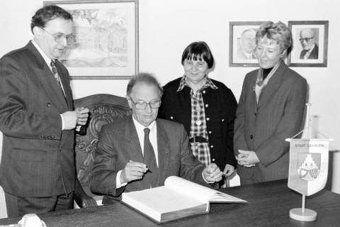 ARH Slg. Weber 02-109/0001, Erster Vorsitzender des Heimatbunds Niedersachsen Peter Hübotter schreibt in das Goldene Buch der Stadt Gehrden mit v.l. Bürgermeister Heinrich Berkefeld, ersten Vorsitzenden der Heimatbund-Ortsgruppe Helga Görsmann u. ersten Stadträtin Christiane Kemnitz, zwischen 1990/2000
