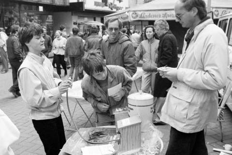 ARH Slg. Weber 02-111/0002, Personen an einem Stand auf einem Fest? in der Fußgängerzone, Gehrden, zwischen 1980/1990