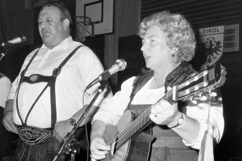 ARH Slg. Weber 02-117/0003, Zwei Personen in Trachten? singen auf einer Veranstaltung in einer Sporthalle, zwischen 1980/1990