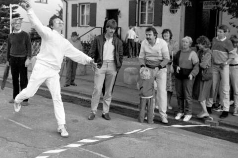 ARH Slg. Weber 02-123/0004, Ein Mann beim Rutenweitwurf vor der Alten Schule/Dorfgemeinschaftshaus während des Straßenfest in Lenthe, zwischen 1980/1990